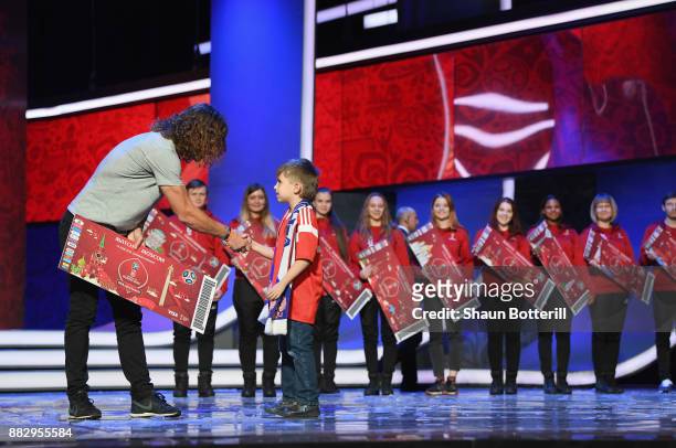 Carles Puyol of Spain greets a Super Fan on the stage after the rehearsal for the 2018 FIFA World Cup Draw at the Kremlin on November 30, 2017 in...