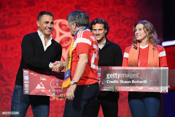 Fabio Cannavaro of Italy greets a Super Fan on the stage as Diego Forlan of Uruguay looks on after the rehearsal for the 2018 FIFA World Cup Draw at...