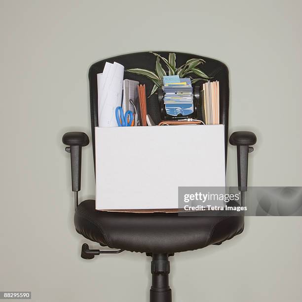 packed box on office chair - downsizing stock pictures, royalty-free photos & images