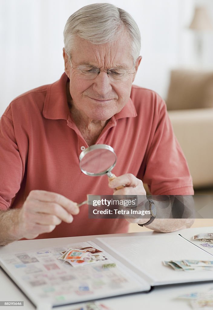 Senior man looking at stamp collection