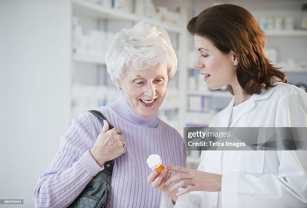 Pharmacist helping senior woman with prescription