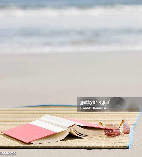 book and sunglasses on beach - beach mat stock pictures, royalty-free photos & images