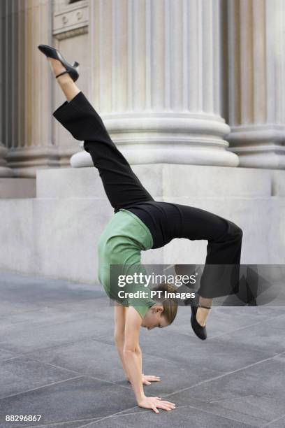 businesswoman dancing on urban sidewalk - hacer el pino fotografías e imágenes de stock