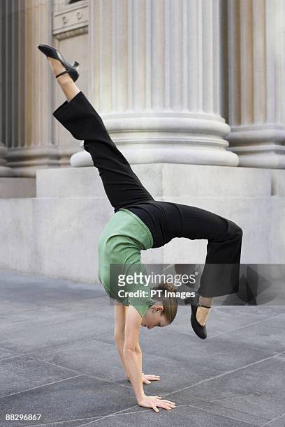 businesswoman dancing on urban sidewalk - businesswoman handstand stock pictures, royalty-free photos & images