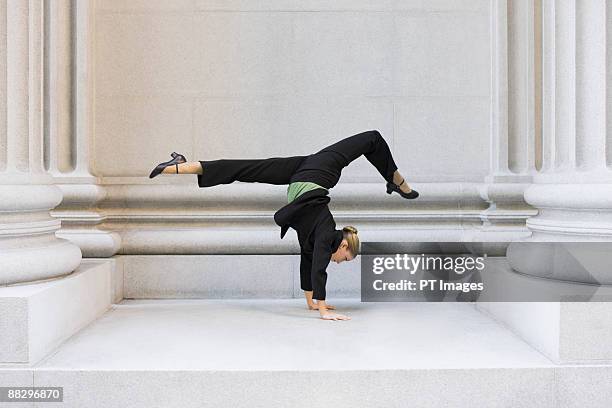 businesswoman dancing in urban setting - businesswoman handstand stock-fotos und bilder