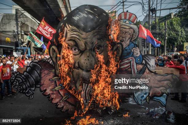 Protesters burn an effigy of Philippine President Rodrigo Duterte and US President Donald Trump during a demonstration against President Rodrigo...