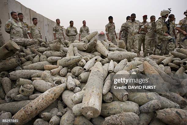 Iraqi Army soldiers gather around thousands of morter rounds found in southern Baghdad on June 8, 2009. The Iraqi military displayed a Saddam...