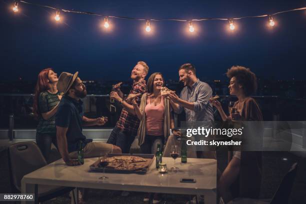 vrolijke vrienden met een diner partij tijdens de nacht op een terras. - party friends stockfoto's en -beelden