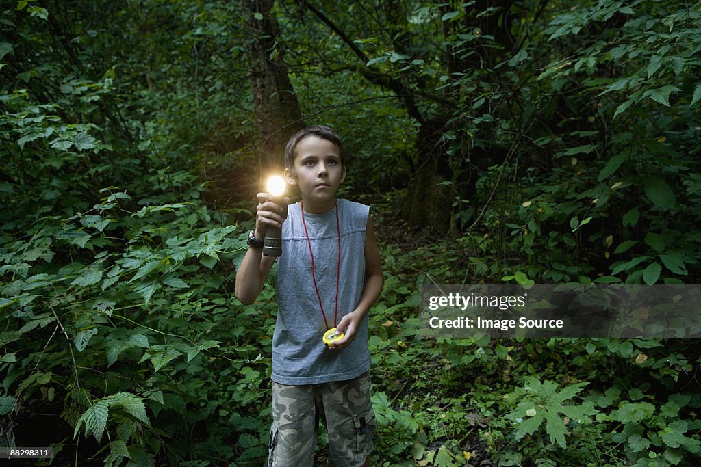 Boy with torch in forest