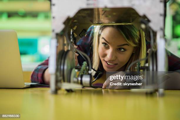 happy woman examining a new robot in laboratory. - electronics engineering students stock pictures, royalty-free photos & images