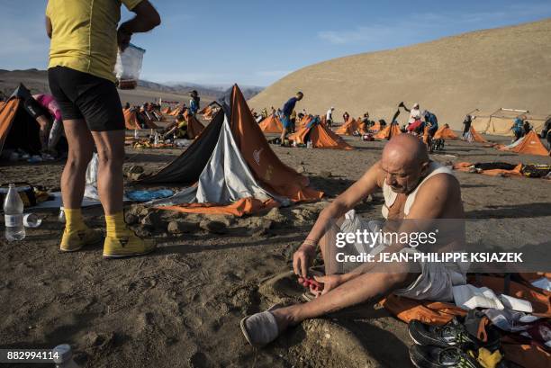 Competitors take a break during the third stage of the first edition of the Marathon des Sables Peru, between Samaca and Ocucaje, in the Ica desert,...