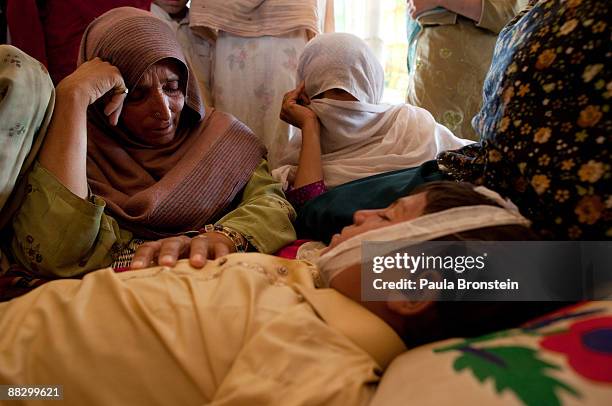 Pakistani women mourn over the body of Muneer Bakht the young boy drowned while swimming in the canal at the Chota Lahore camp June 8, 2009 in Swabi,...