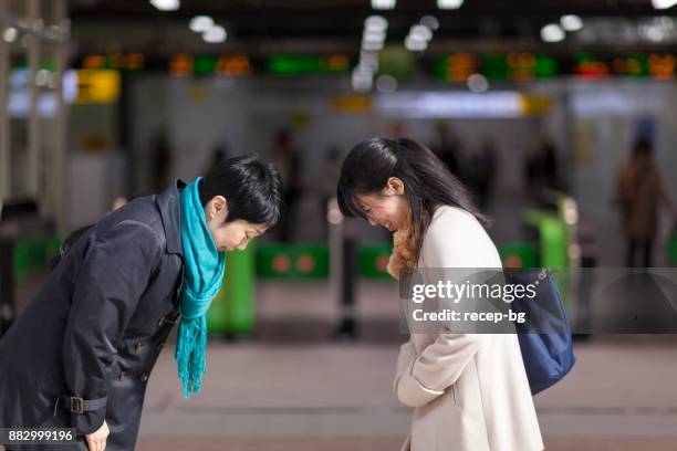 deux femmes d’affaires japonais s’incliner devant l’autre à la station - saluer en s'inclinant photos et images de collection