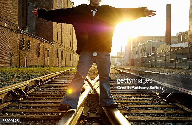 person standing with open arms of railroad tracks - anthony saffery stock pictures, royalty-free photos & images