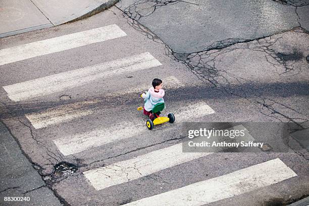 girl in crosswalk with tricycle - anthony saffery stock pictures, royalty-free photos & images