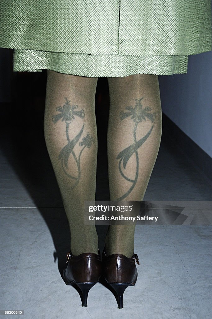 Womans tattooed legs under nylons