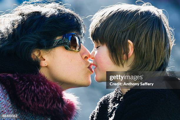 mother kissing son - anthony saffery stock pictures, royalty-free photos & images