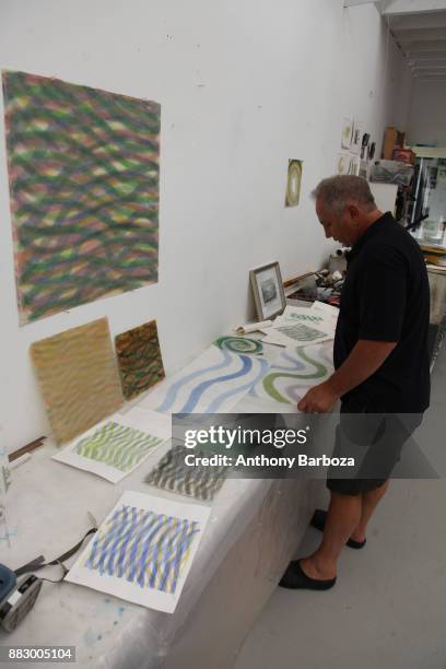 View of American artist Mike Solomon as he looks over a table of his works in his Long Island studio, East Hampton, New York, August 10, 2011.