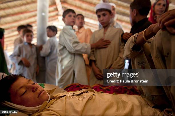 The body of Muneer Bakht as children from the camp look at the young boy who drowned while swimming in the canal at the Chota Lahore camp June 8,...