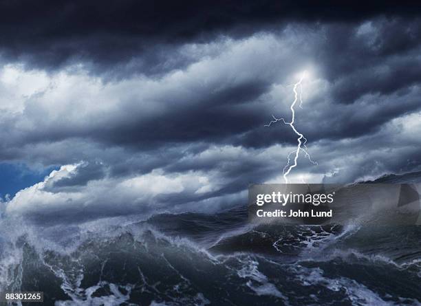 lightning striking over water - burrasca fotografías e imágenes de stock