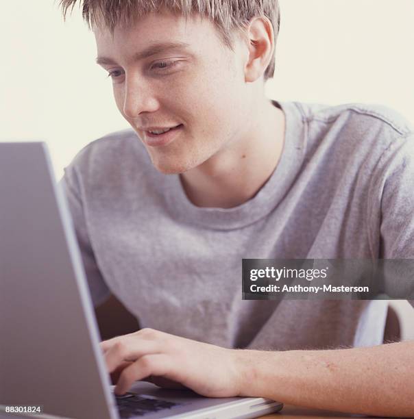 man using laptop computer - anthony masterson photos et images de collection