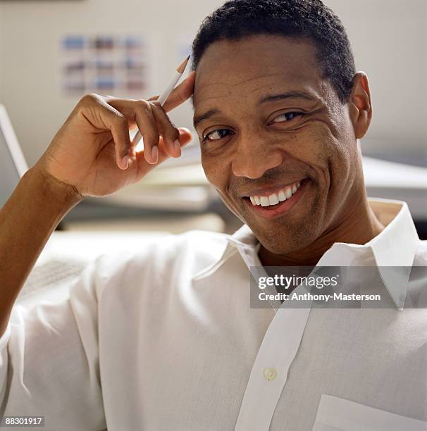 smiling man in office - anthony masterson stock-fotos und bilder