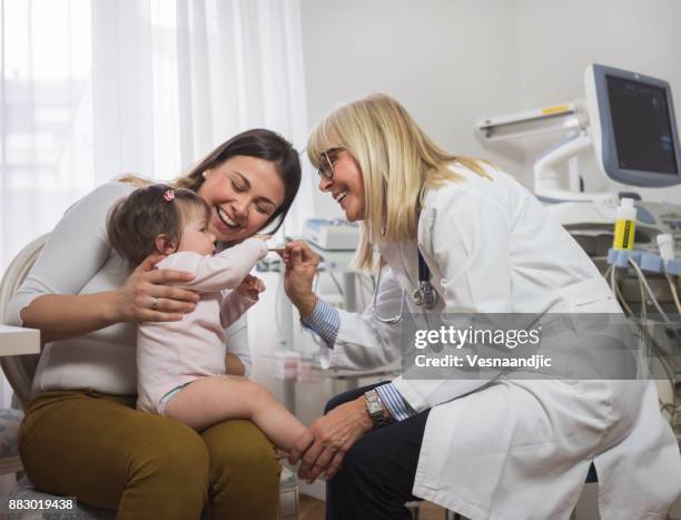 woman with baby girl in doctor's office - doctor and baby stock pictures, royalty-free photos & images