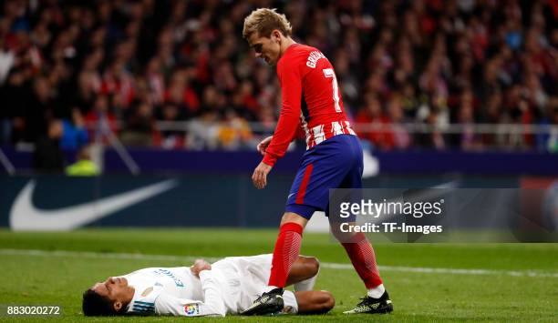 Raphael Varane of Real Madrid on the ground and Antoine Griezmann of Atletico de Madrid is helping during a match between Atletico Madrid and Real...