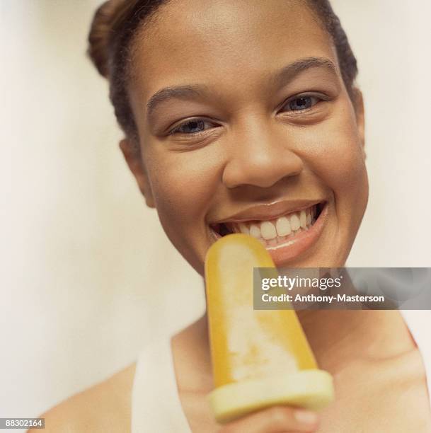 woman with frozen mango pop - anthony masterson stock-fotos und bilder