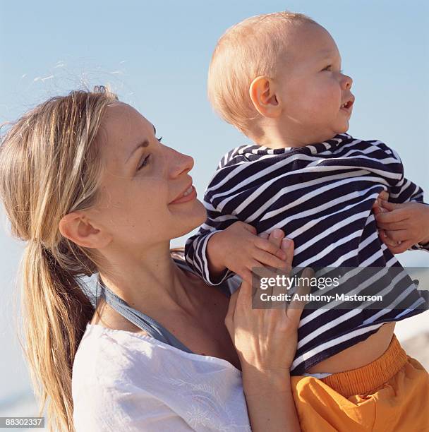 mother holding child outdoors - anthony masterson stock-fotos und bilder