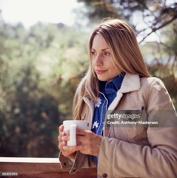 woman holding cup of coffee - anthony masterson stock-fotos und bilder