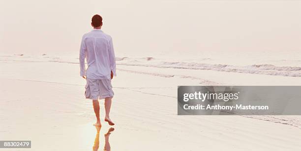 man walking on beach - anthony masterson stock-fotos und bilder