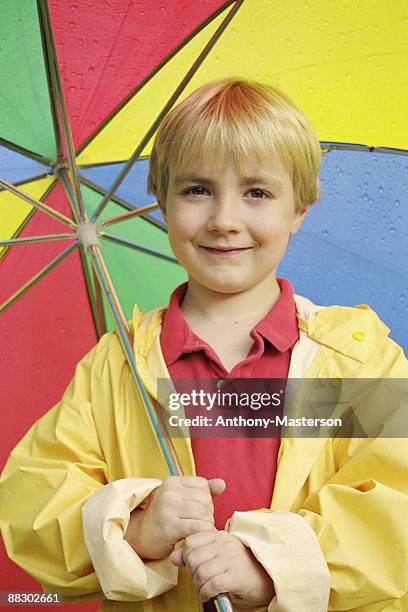 boy with raincoat and umbrella - anthony masterson stock-fotos und bilder
