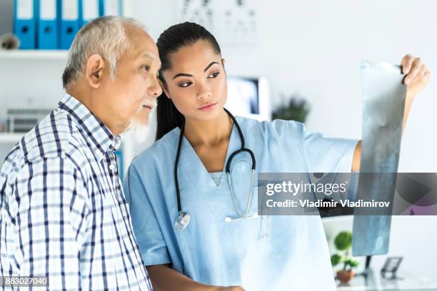 young asian doctor talking to a patient in her cabin - er visit stock pictures, royalty-free photos & images