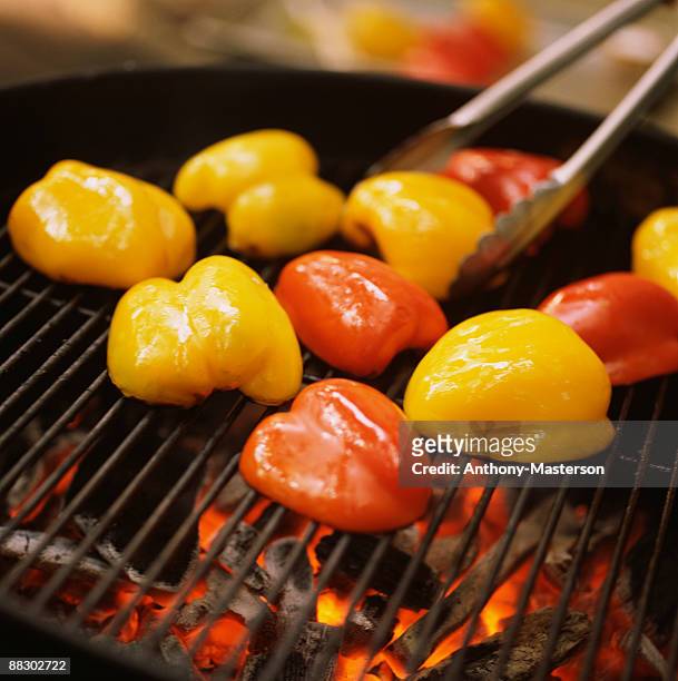 yellow and red peppers on grill - anthony masterson stock-fotos und bilder
