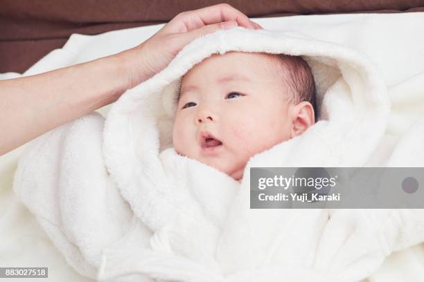 pasgeboren baby in een pluizige witte badjas tikte omhoog door moeder - bath robe stockfoto's en -beelden