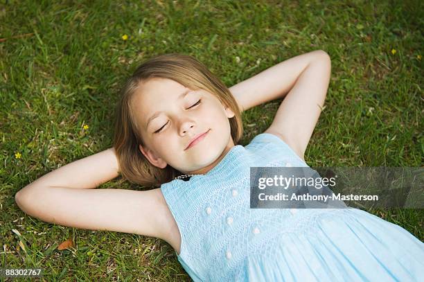 girl lying down in grass - anthony masterson stock-fotos und bilder