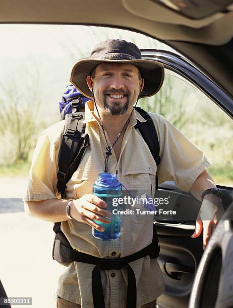 portrait of smiling man backpacking - turner forte stockfoto's en -beelden