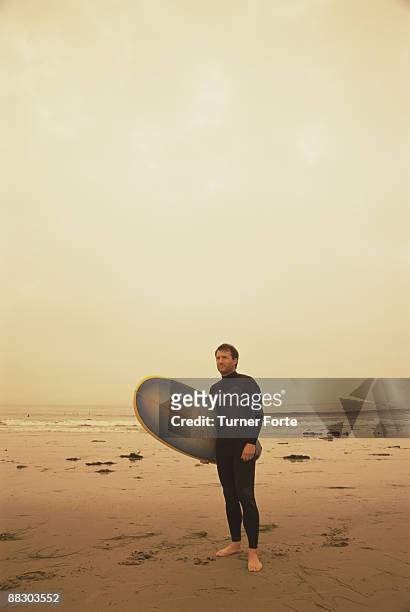 surfer standing on sepia beach - turner forte stockfoto's en -beelden