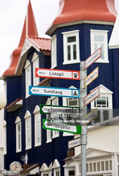 signpost with directions to towns, akureyri, iceland - akureyri foto e immagini stock