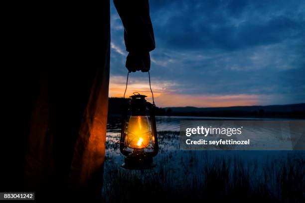 mysterious man in lake - oil lamp stock pictures, royalty-free photos & images