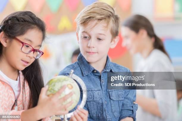 少年は同級生は彼に新しい世界を示して聞く - asian child with new glasses ストックフォトと画像