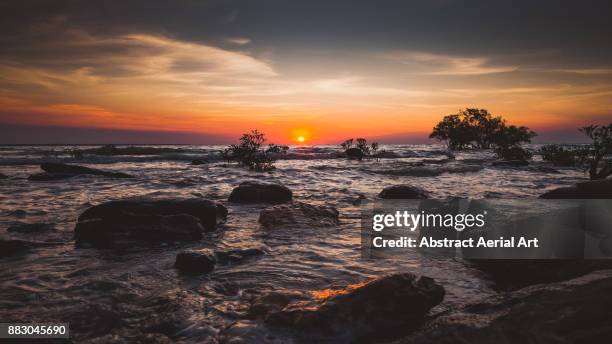 the setting sun looking out over scenic seascape - darwin australia aerial stock pictures, royalty-free photos & images