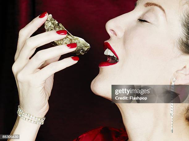 woman eating an oyster - ostron bildbanksfoton och bilder