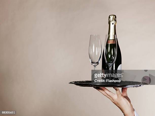 hand holding tray with champagne and glasses - champagne fotografías e imágenes de stock