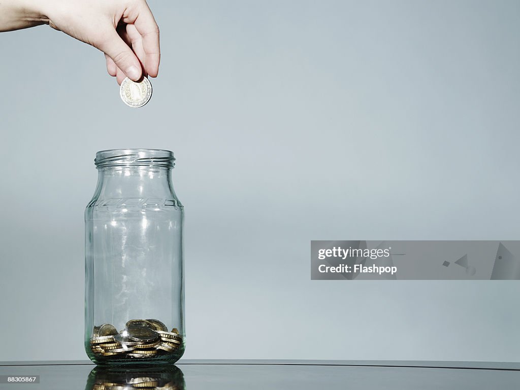 Hand with jar of coins