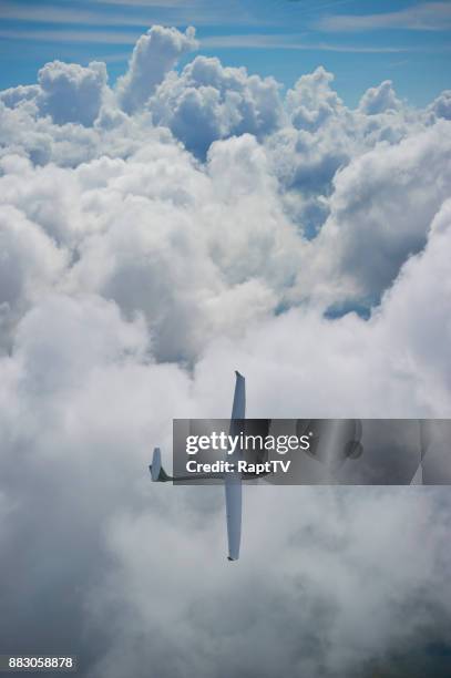 a glider makes a dramatic turn over cumulonimbus clouds. - glider - fotografias e filmes do acervo