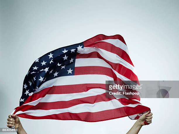 hands holding american flag - usa stockfoto's en -beelden