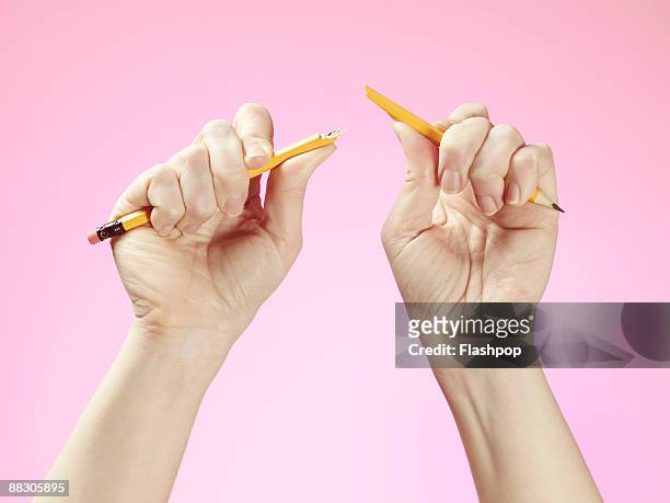 hands holding broken pencil - zerbrechen stock-fotos und bilder