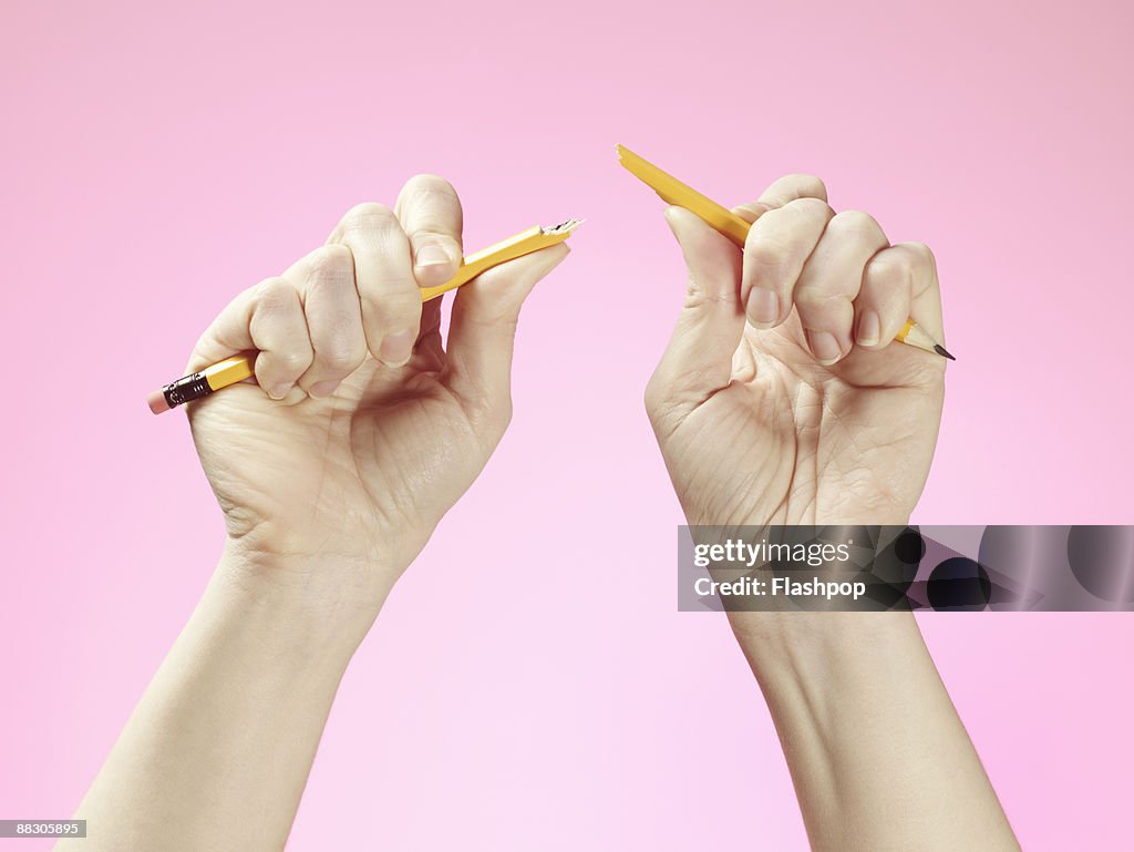 Hands holding broken pencil